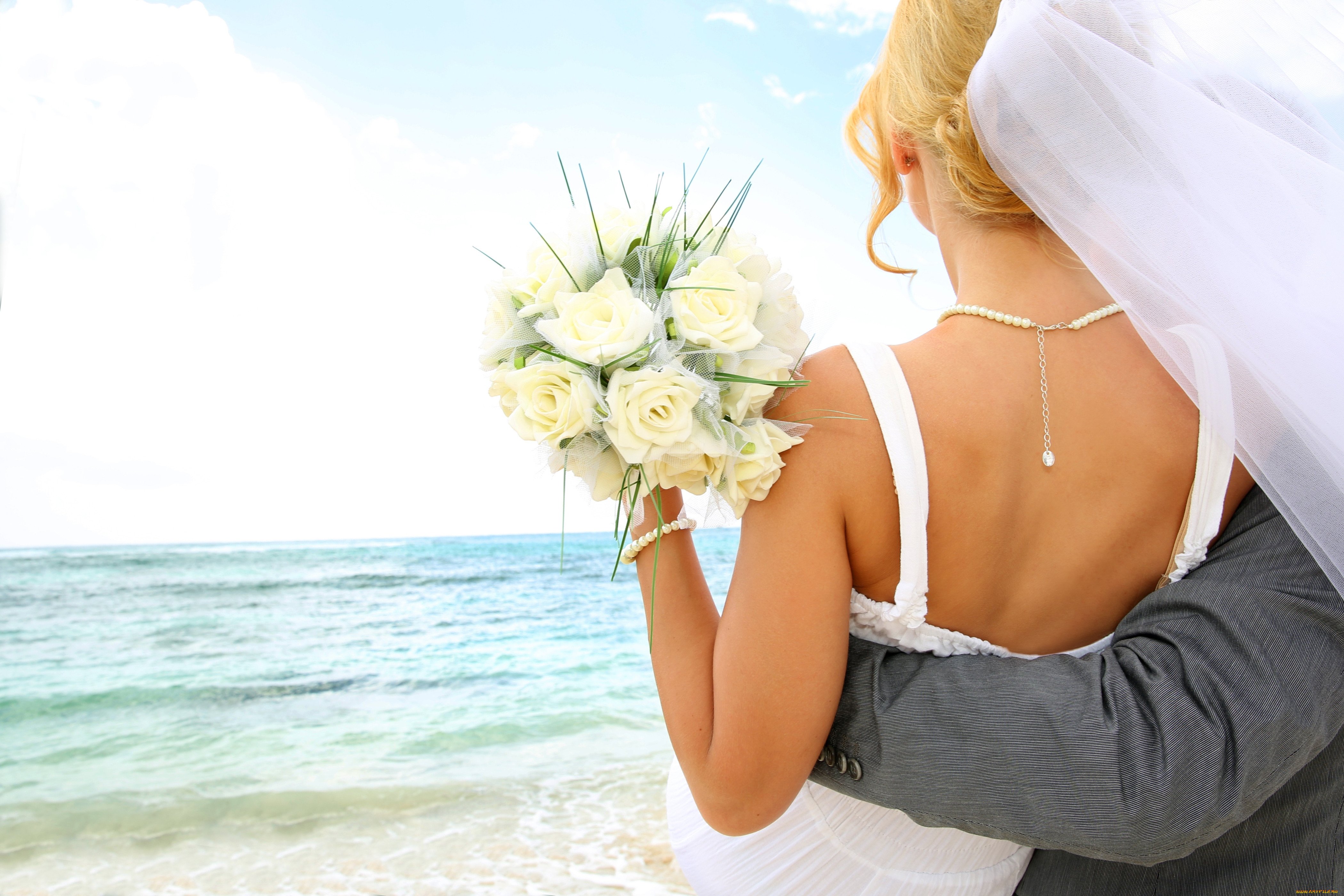Жених и невеста в пляже со спины