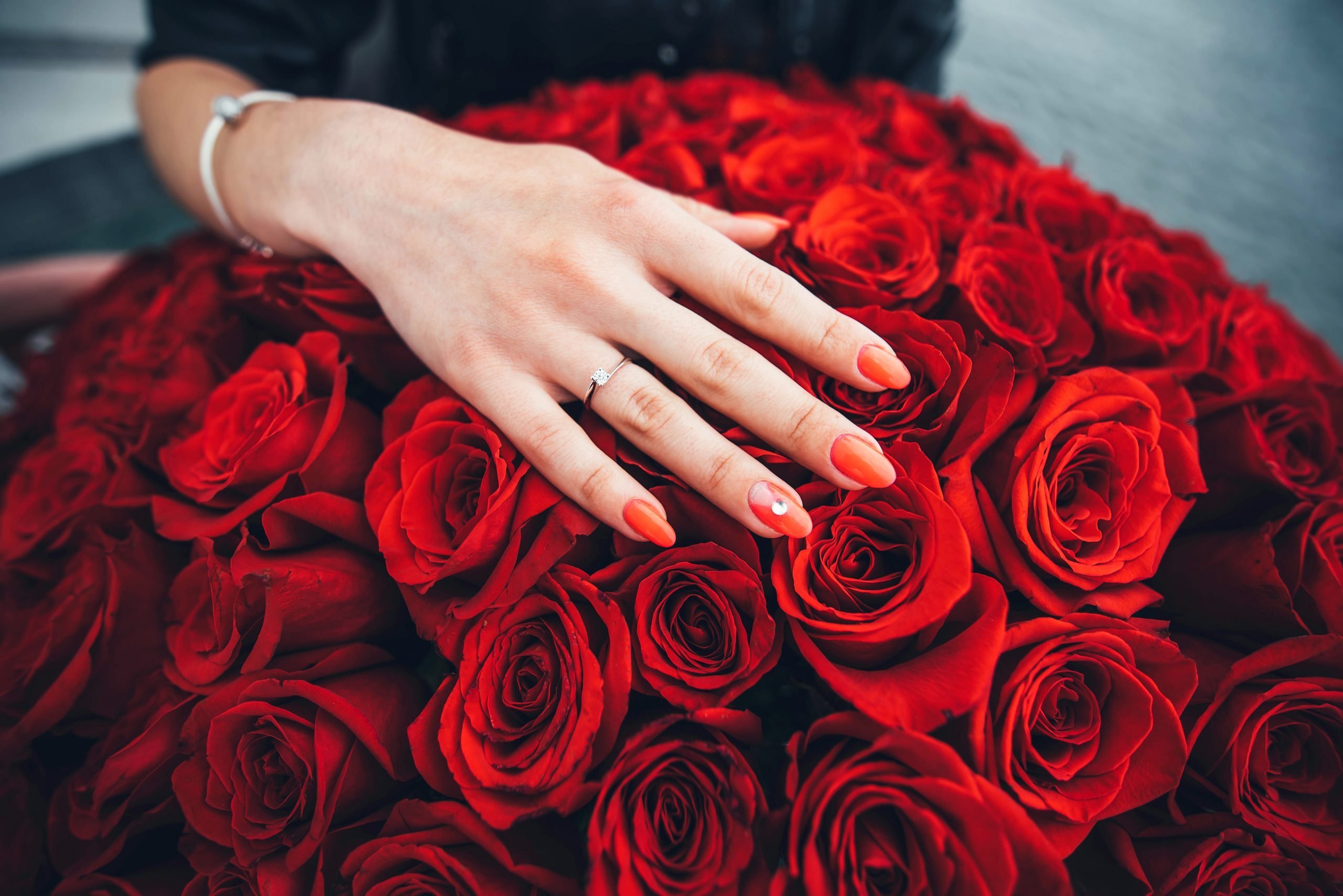 Руки с красным маникюром и розы